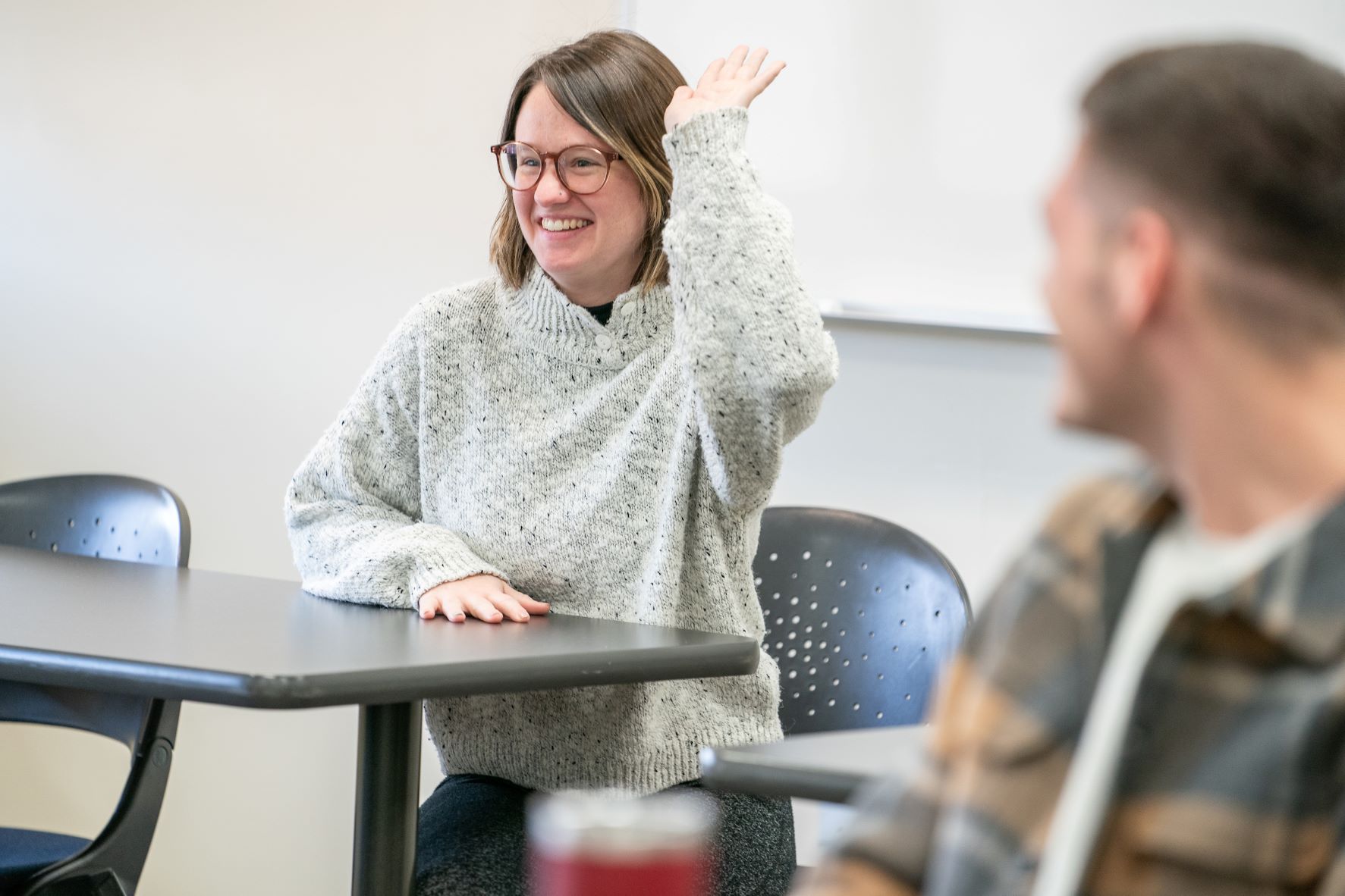 Student raising hand in classroom